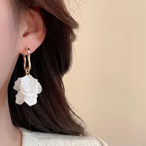 Boucles d'oreilles élégantes en pétales de perles avec crochets dorés sur un mannequin