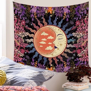 Close-up of bohemian sun and moon tapestry with floral patterns over a bed