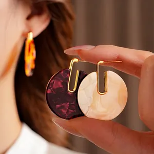 Gold-plated circular acetate earrings in burgundy and cream colors for a retro look