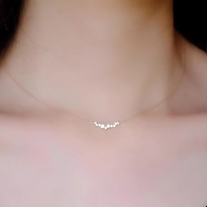 Close-up of a minimalist S925 sterling silver curved diamond smile pendant necklace