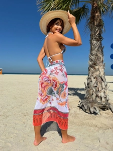 Detail of bohemian floral print mesh sarong and white halter bikini beachwear set