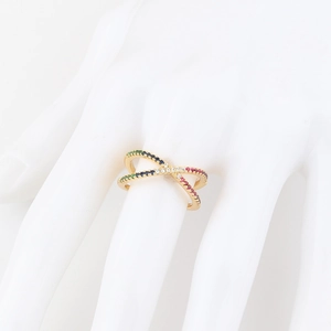 Detail of gold crossover ring with colorful zircon stones on a white hand model