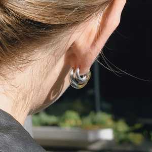 Créoles épaisses en acier inoxydable pour femmes en or et argent portées par un mannequin