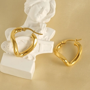 Irregular wave-shaped stainless steel earrings with 18k gold plating on elegant fabric