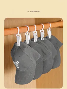 Detail of multi-functional white plastic rotating clips holding gray baseball caps on a rod
