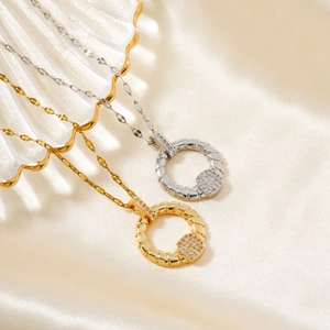 Macro shot of circular twist pendants with micro-inlaid zircons on soft silk fabric