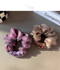 Close-up of violet and champagne mesh scrunchies with elegant bead and flower details