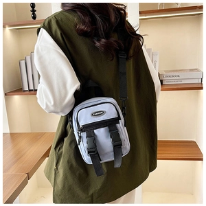 Vista dettagliata del retro di un modello con borsa a tracolla in nylon azzurro in interni