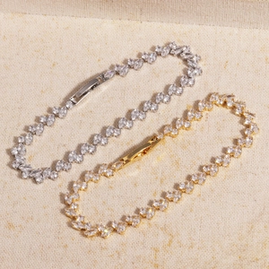 Detail of gold and silver minimalist bracelets with marquise-cut cubic zirconia inlay