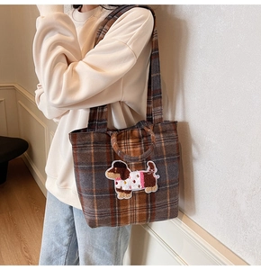 Detail of wool plaid tote bag featuring a cute cartoon dog embroidery and dual handles