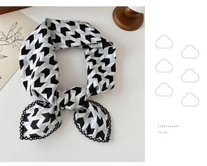 Detail of black and white geometric pattern scarf with delicate lace trimming edge