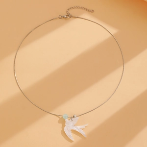 Détail du pendentif hirondelle élégant sur chaîne serpent avec perle bleue subtile