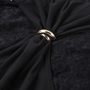 Detail of elegant black lace texture and decorative gold metal ring buckle on dress