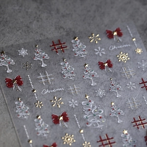 3D embossed Christmas nail stickers featuring red bows and golden snowflakes on gray base