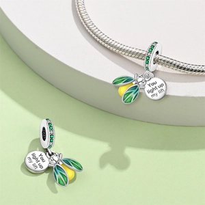Close-up of glow-in-the-dark firefly charm with green enamel and "You light up my life" engraving