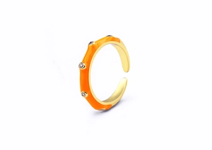 Detailed macro view of an adjustable gold ring with orange enamel and four zircon stones