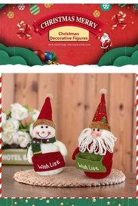 Dettaglio di pupazzi di neve e Babbo Natale in peluche con cesti per la lista dei desideri