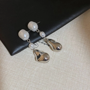 Détail de boucles d'oreilles en perles baroques avec gouttes en métal argenté