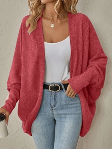 Dettaglio del cardigan in maglia rosso ruggine con trama a costine e maniche a pipistrello