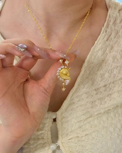 Detail of 18k gold unicorn necklace pendant with clear zircons and star charm on beads chain