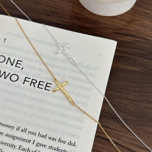 Detail of silver and gold cross necklaces featuring unique handmade hammered textures