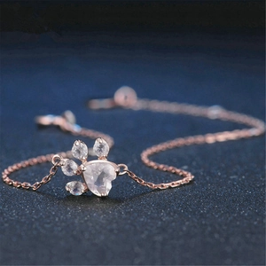 Macro detail of rose gold paw print pendant with pink heart gemstone and crystal accents