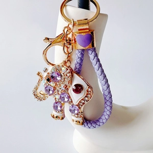 Macro view of crystal elephant keychain with purple rhinestones and woven rope detail