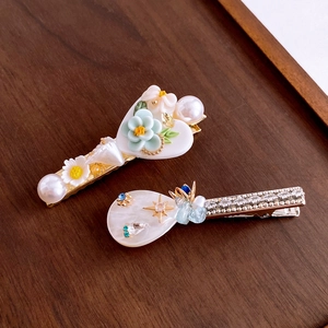 Detail of sweet floral hair clips with heart and teardrop shapes with pearls and rhinestones
