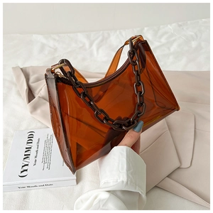 Detail of amber brown transparent PVC underarm bag with decorative resin chain strap