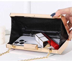 Detailed interior of golden geometric evening clutch bag with black lining and gold chain