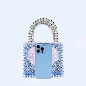Close-up of handmade beaded handbag with heart pattern showing capacity for a smartphone