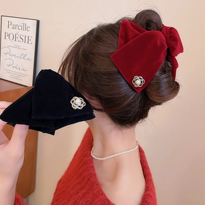 Détail des barrettes à nœuds en velours avec perles blanches et bordures dorées chic