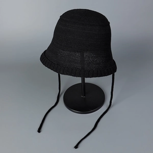 Detail of black breathable knit bucket hat with ties on a display stand