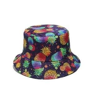 Detail of bucket hat featuring vibrant rainbow pineapple prints on a dark background