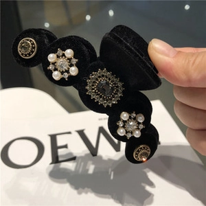 Vue détaillée de la barrette en velours noir ornée de perles élégantes et strass brillants