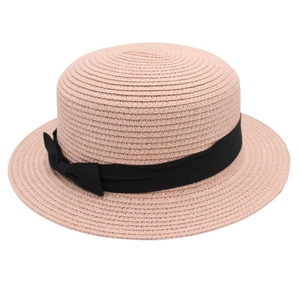 Detail of a pink boater straw hat featuring a flat top and a black grosgrain ribbon bow