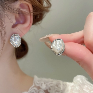 Detail of silver-plated flower earrings with irregular freshwater pearls and metal edges