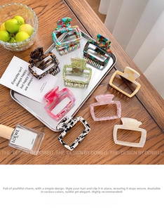 Variety of acetate hair claws in tortoise shell and marble patterns on a wooden table