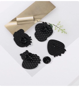 Detailed view of black metal pin backings featuring a honeycomb anti-slip texture surface