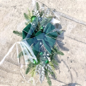 Detail of Christmas stair swag with dark green velvet bow and silver glitter pine cones