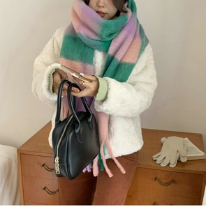 Detail of soft rainbow plaid scarf paired with a white faux fur coat and black leather bag