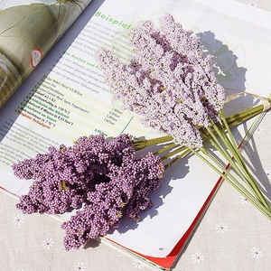 Detailed view of artificial grain ears in light pink and deep purple on an open magazine