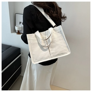 Détail d'un sac fourre-tout en toile blanche avec grandes poches et doubles poignées