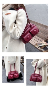 Detail of burgundy glossy leather shoulder bag with double front flap pockets and long strap