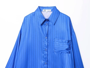 Detail of blue striped satin shirt showing S size label and smooth fabric texture