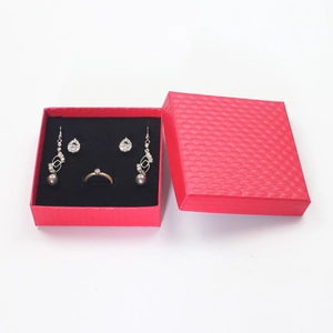 Macro view of a red textured jewelry gift box set with silver rings and earrings