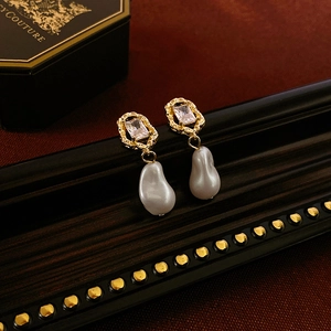 Detail of vintage earrings with baroque pearls and rectangular cubic zirconia crystals