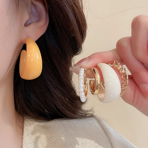 Détails de diverses boucles d'oreilles en acrylique en jaune, crème et blanc perle