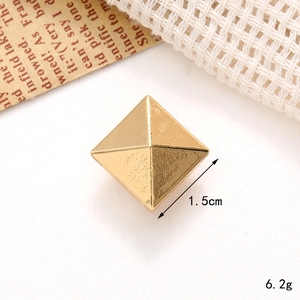 Detail shot of 1.5cm golden pyramid shoe charm showing 6.2g weight and metal texture