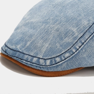 Macro detail of washed denim cap with brown suede brim and contrast blue stitching